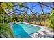 Refreshing pool surrounded by tropical greenery within a screened enclosure at 850 Van Gogh Road, Englewood, FL 34223