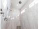 Walk-in shower boasting intricate tile work, dual shower heads and bright natural light at 9214 Melody Cir, Port Charlotte, FL 33981