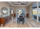 A dining room with modern wood-look tile flooring and views of the screened lanai at 9214 Melody Cir, Port Charlotte, FL 33981