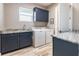 Functional laundry room with a sink, granite countertops, blue cabinets, and a washer and dryer at 9214 Melody Cir, Port Charlotte, FL 33981