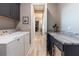 A view down a long hall from the laundry room with modern washer and dryer, a wall of cabinets and granite countertop at 9214 Melody Cir, Port Charlotte, FL 33981