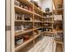 Walk-in pantry featuring wooden shelving, storage for food items and supplies, and tile floors at 9214 Melody Cir, Port Charlotte, FL 33981