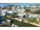 Aerial view of the waterfront property showing boat docks, neighboring houses, and tranquil waters at 9230 Pine Cove Dr, Englewood, FL 34224