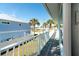 Outdoor balcony with painted railings overlooks a neighborhood with palm trees and blue homes at 9230 Pine Cove Dr, Englewood, FL 34224