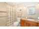 Well-lit bathroom featuring granite counters, wood cabinets, glass block shower, and accessible grab bar at 9230 Pine Cove Dr, Englewood, FL 34224