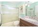 Bright bathroom featuring a shower/tub combo with glass door and granite vanity at 9230 Pine Cove Dr, Englewood, FL 34224