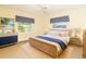 Cozy bedroom featuring a wicker bed frame, dresser, and a window view to the outside at 9230 Pine Cove Dr, Englewood, FL 34224