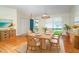 Elegant dining room featuring a woven table and chairs, stylish lighting, and light hardwood flooring at 9230 Pine Cove Dr, Englewood, FL 34224