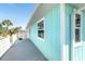 Exterior view of the house showing a porch with a gray floor and light blue siding at 9230 Pine Cove Dr, Englewood, FL 34224