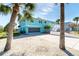 Exterior shot of a home with a 2-car garage and palm trees in the front yard with an all-stone lawn at 9230 Pine Cove Dr, Englewood, FL 34224