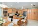 Spacious kitchen with light wood cabinets, granite countertops, an island with seating, and modern appliances at 9230 Pine Cove Dr, Englewood, FL 34224