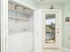 Functional laundry room with washer, dryer, shelving, and access to the screened porch at 9230 Pine Cove Dr, Englewood, FL 34224