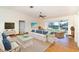 Bright living room featuring a comfortable white sofa, woven chairs, and sliding glass doors to the outside at 9230 Pine Cove Dr, Englewood, FL 34224