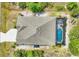 Birds-eye view of house featuring a screened in pool, well-kept roof, and a lovely green lot at 9283 Impala Cir, Port Charlotte, FL 33981