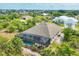 An aerial view showcases a private pool enclosure and a lush, landscaped yard in a serene setting at 9283 Impala Cir, Port Charlotte, FL 33981