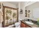 Bathroom with a granite-topped vanity, toilet, and palm-themed shower curtain at 9283 Impala Cir, Port Charlotte, FL 33981