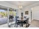 Bright dining area features an elegant chandelier, tile flooring, and sliding glass doors to the lanai at 9283 Impala Cir, Port Charlotte, FL 33981