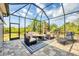 Inviting screened lanai featuring comfortable seating around a cozy fire pit, creating an ideal outdoor living space at 9283 Impala Cir, Port Charlotte, FL 33981