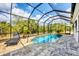 Enclosed pool area featuring a tranquil pool, lounge chair, and elegant paving at 9283 Impala Cir, Port Charlotte, FL 33981