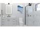 Modern bathroom features a walk-in shower with black hardware, an illuminated mirror, and white marble-like tile at Lot 18 Blk 284 Wooley Ave, North Port, FL 34287