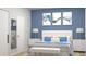 This bedroom has a blue accent wall, plush bedding, and decorative artwork at Lot14 Blk285 Houston Ln, North Port, FL 34287