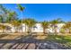 Well-maintained backyard showcasing a white fence lined with palm trees and decorative rock landscaping at 10039 Sunday Dr, Port Charlotte, FL 33981