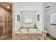 A spa-like bathroom featuring a luxurious soaking tub, a separate tiled shower, and ample natural light at 10039 Sunday Dr, Port Charlotte, FL 33981