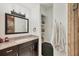 This bathroom is bright with a granite vanity, a framed mirror and linen storage at 10039 Sunday Dr, Port Charlotte, FL 33981