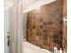 A shower-tub combination features mosaic tiles and a shower curtain at 10039 Sunday Dr, Port Charlotte, FL 33981