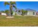 Charming single-story home featuring a metal roof, verdant landscaping, and a well-manicured lawn at 10039 Sunday Dr, Port Charlotte, FL 33981