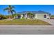 Attractive single-story home with a well-kept lawn, complemented by lush landscaping and a durable metal roof at 10039 Sunday Dr, Port Charlotte, FL 33981