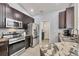 Modern kitchen featuring stainless appliances, dark wood cabinets, and granite countertops at 10039 Sunday Dr, Port Charlotte, FL 33981