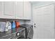Convenient laundry room featuring modern LG washer and dryer, white cabinets for storage, and a door leading outside at 10039 Sunday Dr, Port Charlotte, FL 33981