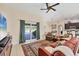 Bright living room with tiled floors, ceiling fan, and sliding doors to the outdoor patio at 10039 Sunday Dr, Port Charlotte, FL 33981