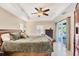 Spacious main bedroom featuring a tray ceiling with fan, and sliding glass doors to the pool area at 10039 Sunday Dr, Port Charlotte, FL 33981