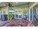 Cozy covered patio with fan, a TV, Boca Grande sign, potted plants, and outdoor seating facing the pool at 10039 Sunday Dr, Port Charlotte, FL 33981