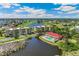 Aerial view of building exteriors near water and a golf course. Red roofs and tan siding at 10055 Links Ln # 402, Rotonda West, FL 33947