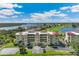 Stunning aerial view of condo building with a red roof, water views, and manicured landscaping at 10055 Links Ln # 402, Rotonda West, FL 33947