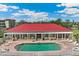 Aerial view of the community pool with a red roofed building, white fencing, and many lounge chairs at 10055 Links Ln # 402, Rotonda West, FL 33947