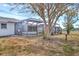 View of the back yard with screened-in pool area, trees and lawn at 10060 Amelia Ave, Englewood, FL 34224