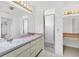 Bathroom featuring a dual sink vanity, a walk-in shower, and decorative lighting at 10060 Amelia Ave, Englewood, FL 34224