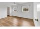 Bright bedroom featuring wood-look flooring, two windows, a ceiling fan, and a walk-in closet at 10060 Amelia Ave, Englewood, FL 34224