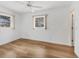 Bright bedroom featuring wood-look flooring, two windows, and neutral colored walls at 10060 Amelia Ave, Englewood, FL 34224