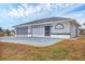 Home's exterior featuring an attached garage, a fenced yard, and a large driveway at 10060 Amelia Ave, Englewood, FL 34224