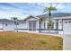 Charming single-Gathering home featuring a screened entryway, palm trees, and manicured gravel at 10060 Amelia Ave, Englewood, FL 34224