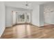 Bright living room featuring hardwood floors, large bay windows, and a modern ceiling fan at 10060 Amelia Ave, Englewood, FL 34224