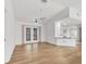 Bright living room with vaulted ceilings, wood floors, a ceiling fan, and french doors at 10060 Amelia Ave, Englewood, FL 34224