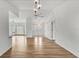 Bright living room with hardwood floors, ceiling fan, decorative light fixtures, and double doors at 10060 Amelia Ave, Englewood, FL 34224
