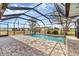Screened-in pool with brick patio and a view of the back yard at 10060 Amelia Ave, Englewood, FL 34224