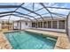 Screened-in pool featuring a brick-lined edge and clear blue water for backyard fun and relaxation at 10060 Amelia Ave, Englewood, FL 34224